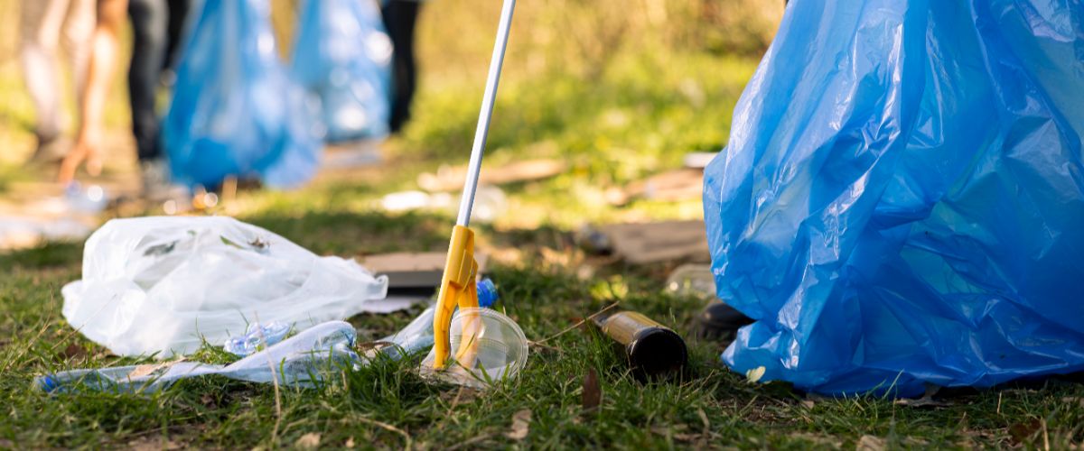 Activist using claw tool collect rubbish plastic junk from ground (2)